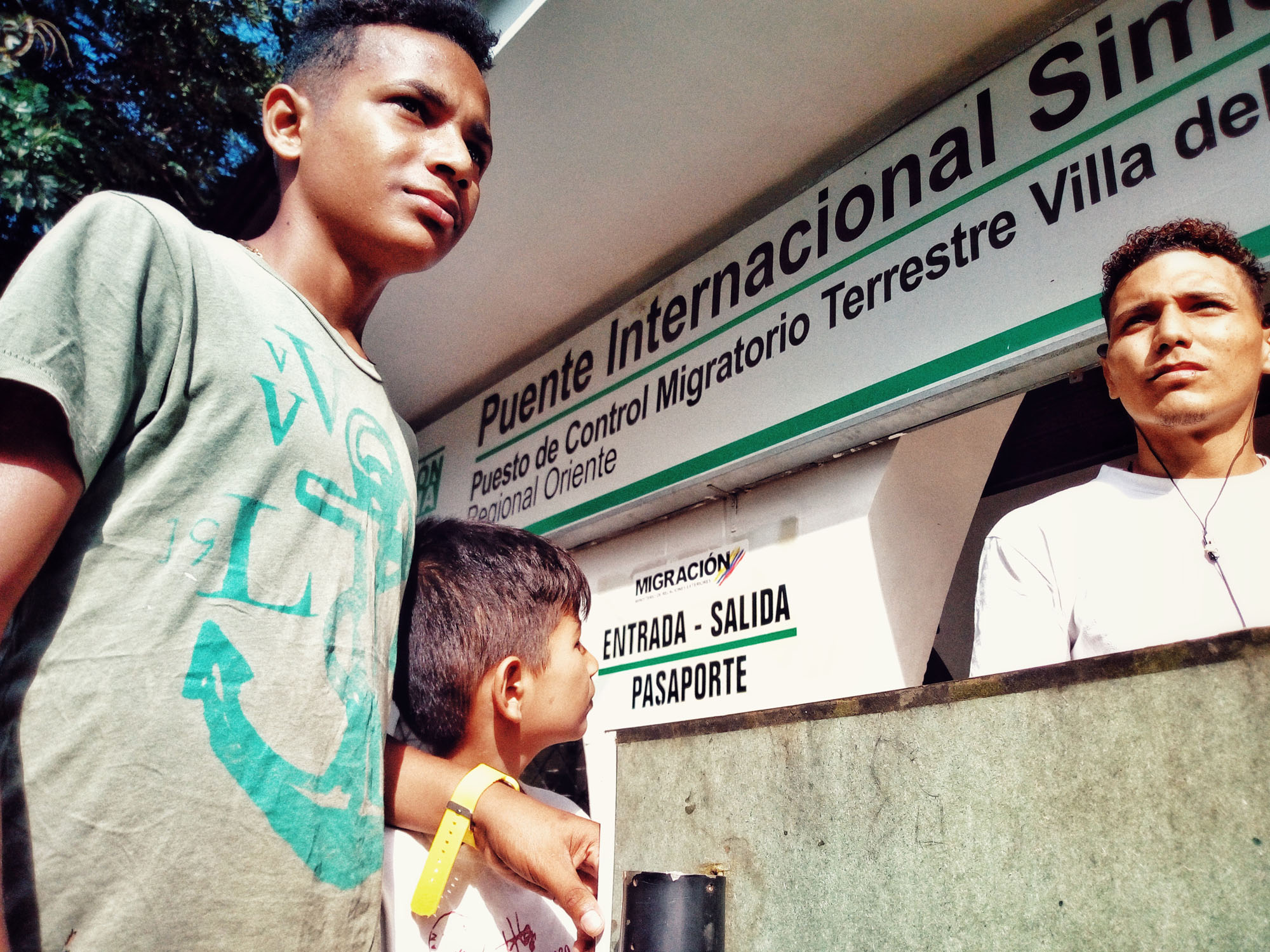 The siblings are waiting at the border in front of the Colombian immigration building to obtain the migration card that will allow them to take the bus across the Colombian border with Ecuador. 