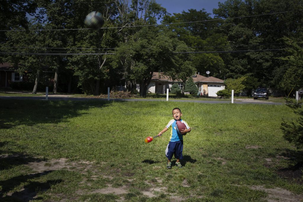 Retrato de Juan jugando Fútbol en su casa en new Jersey, después de unos días de haber sido reunificado su mamá Betty, New Jersey USA, 2018.